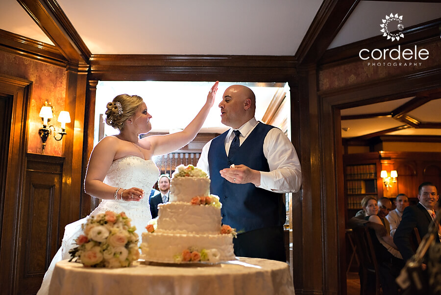 A bride and groom have their cake cut at the Wedding in Dedham Ma