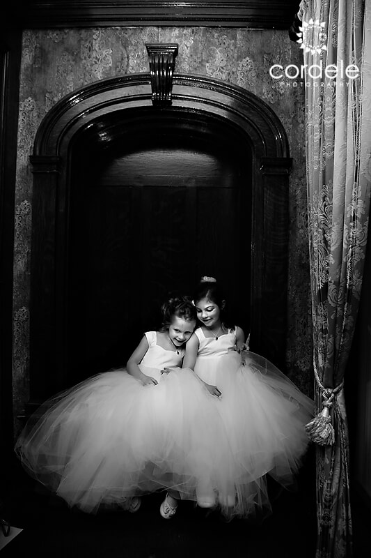 A couple flower girls sit on a bench at the Endicott Estate